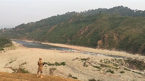 A Pakistani soldier stands guard facing the invisible line separating the two regions of Jammu and Kashmir in 2016.
