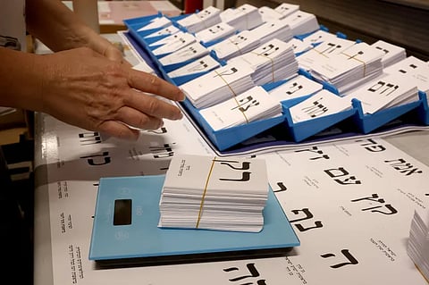 A worker weighs newly printed ballot papers at a factory in Kiryat Gat in southern Israel, on Thursday, October 8, 2026.