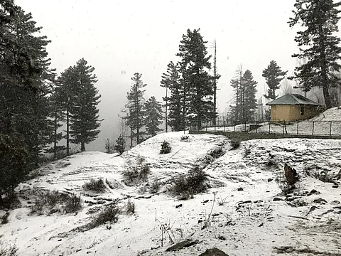 A white blanket of fresh snow covers the roadside hills at Tangmarg in Baramulla district of Kashmir on Saturday, December 16, 2023. KT Photo/Sajad Ahmad