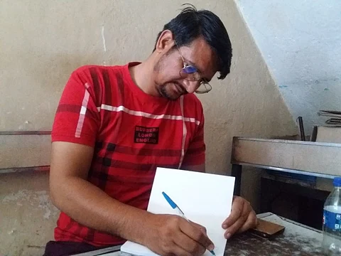 Deeraj Bismil signing a copy of his award winning book ‘Ahlada’ which he gifted to the author. Photos/Aman Zutshi)