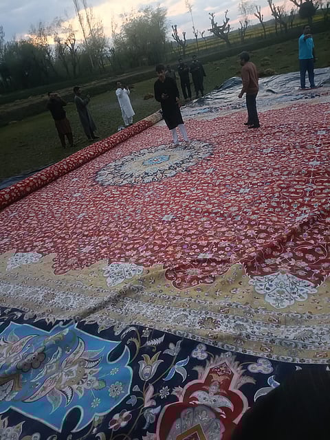 The longest silk carpet produced by master craftsmen of Kashmir, eight years of hard work with 365 million knots, being rolled out for washing on the banks of Dal Lake, Srinagar before its export to Saudi Arabia. Photo/Sheikh Mustafa