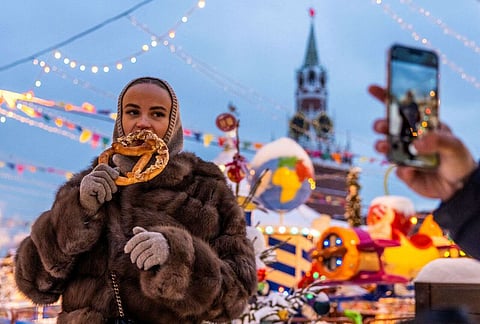 امرأة تلتقط صورة مع حلوى في سوق رأس السنة وعيد الميلاد في الساحة الحمراء في موسكو، روسيا، 15 ديسمبر 2023. ملف رويترز