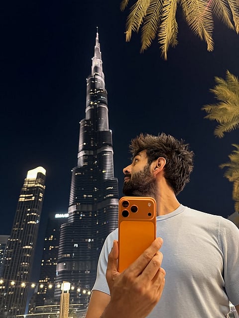 كارتيك أريان يستعرض هاتفه الجديد آيفون 17 أمام برج خليفة