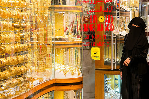 متسوقة تستطلع المجوهرات الذهبية في دبي.