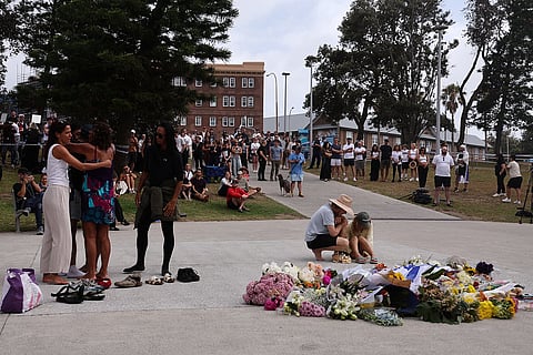 يتجمع الناس في موقع خارج جناح بوندي. صورة: AFP