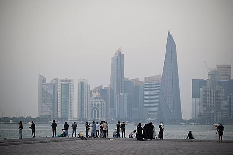 يقف الناس على الكورنيش المطل على أفق المدينة في الدوحة بتاريخ 13 يناير 2026. الصورة: وكالة الأنباء الفرنسية