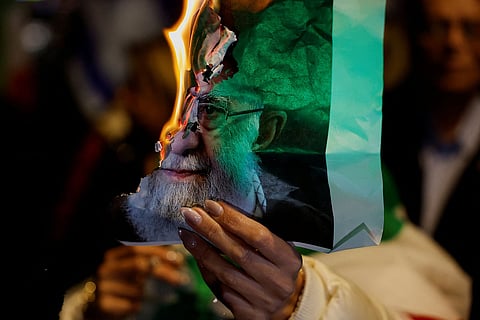 امرأة تحمل صورة محترقة للمرشد الأعلى الإيراني آية الله علي خامنئي