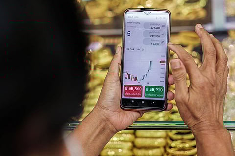 امرأة تستخدم Gold Now، وهو تطبيق لتداول الذهب والادخار عبر الإنترنت تم تطويره بواسطة تاجر الذهب التايلاندي هوا سينغ هينغ، على هاتفها المحمول وهي تتحقق من سعر الذهب