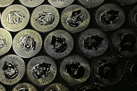 عملات سبائك الفضة توضع على حزام ناقل أثناء الإنتاج في دار سك العملة الملكية في بونتي كلون، ويلز.