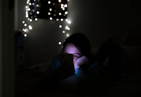 مراهقة تستخدم هاتفها في غرفتها