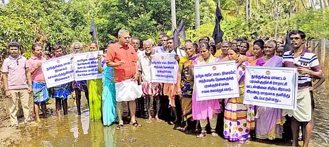 கருப்புக்கொடியுடன் தண்ணீரில் இறங்கி ஆர்ப்பாட்டம் செய்த பொதுமக்கள்.
