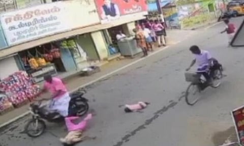 மோட்டார் சைக்கிள் மோதியதில் சாலையில் விழுந்த சிறுமி, குழந்தை.