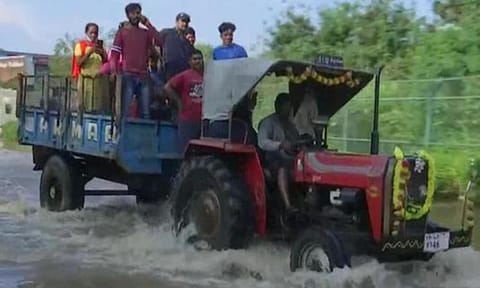 ஐ.டி. ஊழியர்கள் டிராக்டரில் பணிக்கு செல்வதை படத்தில் காணலாம்.