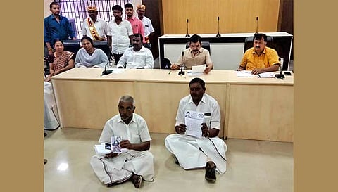 தர்ணாவில் ஈடுபட்ட அ.தி.மு.க. கவுன்சிலரை படத்தில் காணலாம்.