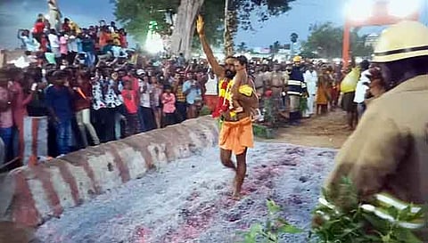 கைக்குழந்தையுடன் பூக்குழி இறங்கிய பக்தர்.