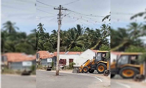 நடுரோட்டில் உள்ள மின்கம்பத்தை படத்தில் காணலாம்.