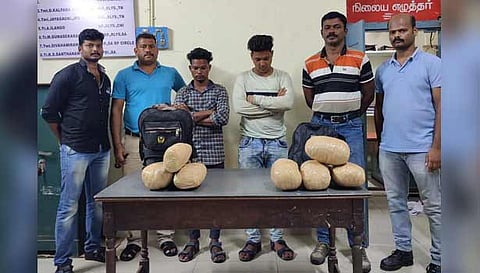 கைதான 2 பேர் மற்றும் பறிமுதல் செய்யப்பட்ட கஞ்சா பொட்டலங்களுடன் போலீசார்.