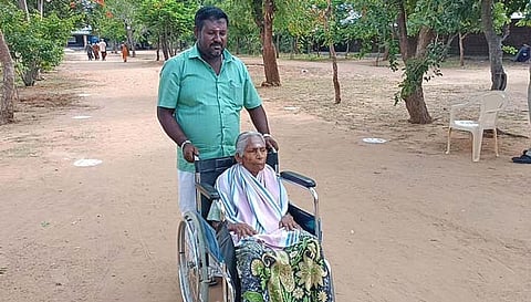 பிள்ளாநல்லூரில் ஓட்டு போடுவதற்காக வயதான மூதாட்டியை சக்கர நாற்காலியில் அமர வைத்து அழைத்துச் சென்ற காட்சி.