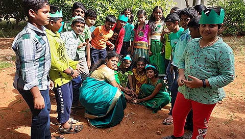 ஆசிரியைகள் மற்றும் மாணவர்கள் மரக்கன்றுகளை நட்டனர்.