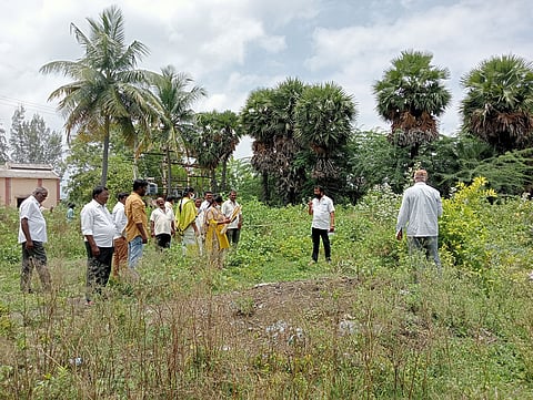 நிலம் அளவிடும் பணியில் அதிகாரிகள் ஈடுபட்ட காட்சி.