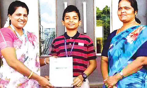  மாணவன் ஜெயோஷ் கிஷோரை பள்ளி நிர்வாகத்தினர் பாராட்டிய காட்சி.