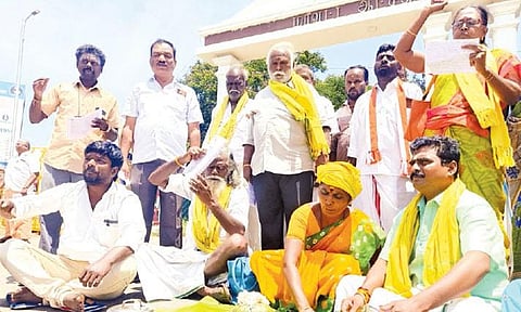 தேனி கலெக்டர் அலுவலகம் முன்பு முழு பூசணிக்காயை சோற்றில் மறைத்து போராட்டம் நடத்தியவர்களை படத்தில் காணலாம்.