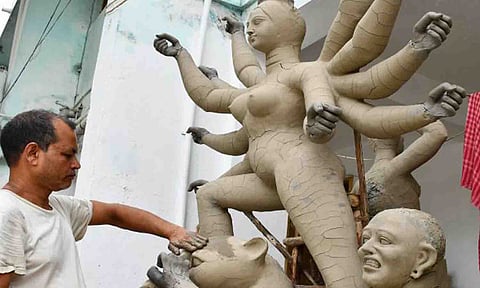 துர்கா சிலைகள் வடிவமைக்கும் பணிகளில் ஈடுபட்டுள்ள கைவினை கலைஞரை படத்தில் காணலாம்.