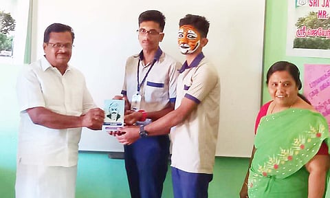 போட்டியில் பங்கேற்ற மாணவருக்கு பரிசு வழங்கப்பட்ட காட்சி.