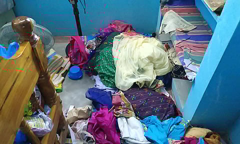 பீரோ உடைக்கப்பட்டு பொருட்கள் சிதறி கிடக்கும் காட்சி.