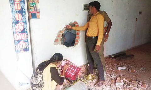 அடகு கடையின் பின்புற சுவற்றில் மர்ம நபர்கள் துளையிட்ட இடத்தில் கைரேகை நிபுணர்கள் ஆய்வு செய்த காட்சி.