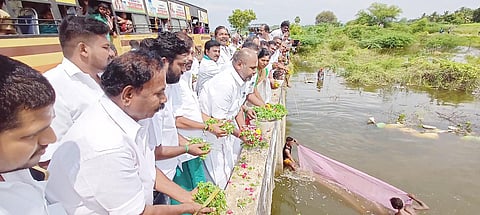 கண்மாய் நிரம்பி மறுகால் பாய்ந்த தண்ணீரில் முன்னாள் அமைச்சர் ஆர்.பி.உதயகுமார் மலர்கள் தூவினார்.