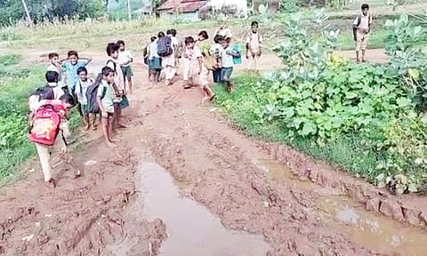 சேறும் சகதியுமான சாலையில் சிரமப்பட்டு செல்லும் மாணவ-மாணவிகள்.