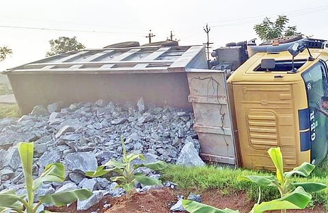 கவிழ்ந்து கிடக்கும் லாரியை படத்தில் காணலாம்.