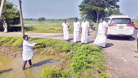 மழைநீரில் மூழ்கியுள்ள பாதிக்கப்பட்ட பயிரை பன்னீர்செல்வம் எம்.எல்.ஏ.விடம் காட்டும் விவசாயி.