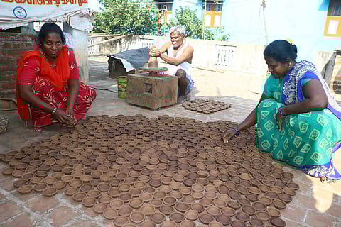 கார்த்திகை தீப திருவிழாவையொட்டி வேலூர் காகிதப்பட்டறையில் தயார் செய்யப்பட்ட அகல் விளக்கை உலர்த்தும் பணியில் ஈடுபட்டுள்ள பெண்கள்.