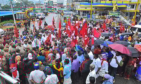 கொட்டும் மழையில் மறியலில் ஈடுபட்ட தொழிலாளர்கள்.