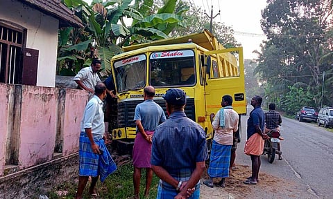 வீட்டு காம்பவுண்ட் சுவரில் மோதி நிற்கும் கனரக வாகனம்