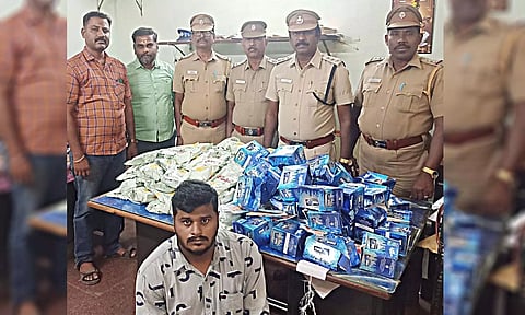 பறிமுதல் செய்யப்பட்ட குட்கா-புகையிலை பாக்கெட்டுகளுடன் கைதான விக்னேசையும், அவரை பிடித்த போலீசாரையும் படத்தில் காணலாம்.