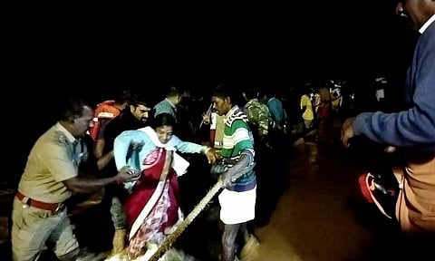 பக்தர்களை தீயணைப்பு வீரர்கள் கயிறு கட்டி மீட்ட போது எடுத்தப்படம்.