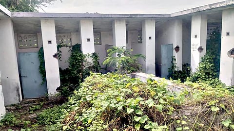 புதர்மண்டி கிடக்கும் பொது கழிப்பறை கட்டிடம். 