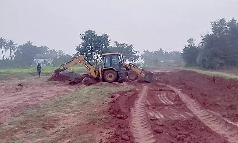 மண் அள்ளப்படும் இடத்தில் நிற்கும் பொக்லின் எந்திரம்.