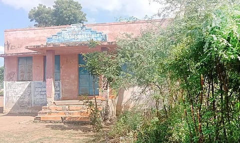 கருவேல மரங்களால் சூழ்ந்துள்ள நூலக கட்டிடம்.