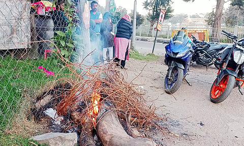 ஏரிச்சாலை ஜிம்கானா மைதானம் அருகே தீமூட்டி குளிர்காயும் பொதுமக்கள்.