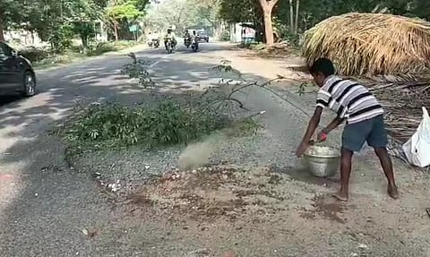 சாலையை சீரமைக்கும் சிறுவன்