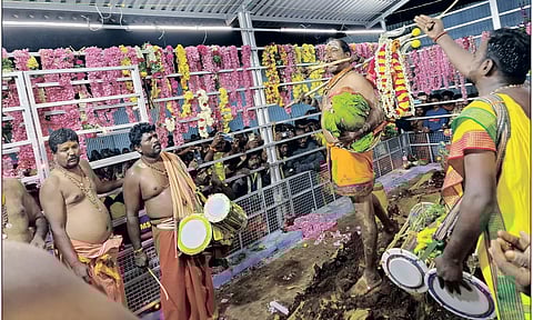 மயான பூஜையில் அம்மன் அருளாளி கையில் சூலாயுதம் ஏந்தி வாயில் எலும்பை கவ்வியபடி ஆடிய காட்சி.