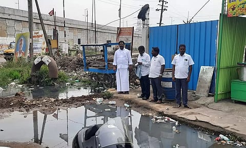 மழைநீர் கால்வாயில் தேங்கியுள்ள கழிவு நீரை அதிகாரிகள் பார்வையிட்டபோது எடுத்த படம்