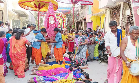 குடியாத்தம் தாழையாத்தம் அங்காளபரமேஸ்வரி அம்மன் கோவிலில் நேர்த்திக் கடன் செலுத்த பூங்கரகம் முன்பு பெண்கள் தரையில் படுத்திருந்த காட்சி.