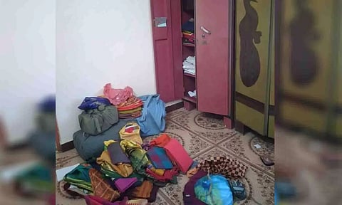 பீரோவில் இருந்த துணிமணிகள் சிதறி கிடப்பதை படத்தில் காணலாம்.