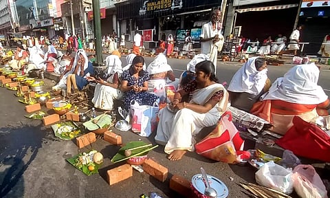 ஆற்றுக்கால் பகவதி அம்மன் கோவில் முன்பு சாலையில் பொங்காலையிடும் பெண்கள்.