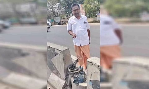 பல்லடம் சாலை தடுப்பில் இருந்த மின் கம்பம் கழற்றப்பட்டுள்ளதை படத்தில் காணலாம்.